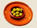 Grüne Oliven in einer Tonschale angerichtet, so bekommt man in Andalusien kleine Vorspeisen serviert wie hier auf dem Bild zu sehen ist.